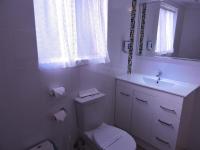 a white bathroom with a toilet and a sink at Acacia Snowy Motel in Jindabyne
