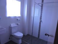 a bathroom with a toilet and a glass shower at Acacia Snowy Motel in Jindabyne