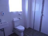a white bathroom with a toilet and a shower at Acacia Snowy Motel in Jindabyne