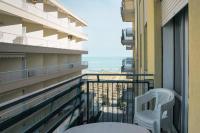 Un balcón con una silla y vistas al océano. en [Blu Kobler] - Ampio appartamento fronte mare, en Lido di Jesolo