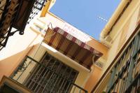 a building with a balcony with a curtain on it at Pensión San Benito Abad in Seville