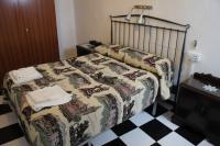 a bedroom with a bed with a quilt on it at Pensión San Benito Abad in Seville