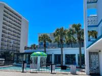 ein Gebäude mit Palmen und einem Regenschirm in der Unterkunft Polynesian Oceanfront Hotel in Myrtle Beach