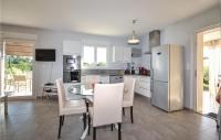 a kitchen and dining room with a table and a refrigerator at 2 Bedroom Amazing Home In Saint-ambroix in Saint-Ambroix