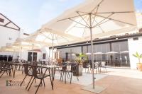 een buitenterras met tafels, stoelen en parasols bij Hotel Rural el Turuñuelo in Guareña