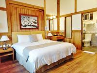 a bedroom with a large bed and a bathroom at Shiyai Taoyuan in Ren&#39;ai
