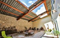 a patio with a stone wall and a wooden ceiling at Cozy Home In Merindol With Outdoor Swimming Pool in Mérindol