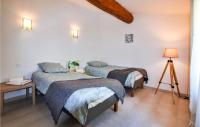 a bedroom with two beds and a table with a lamp at Cozy Home In Merindol With Outdoor Swimming Pool in Mérindol