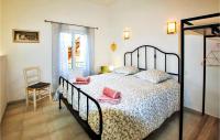 a bedroom with a bed with pink pillows and a chair at Cozy Home In Merindol With Outdoor Swimming Pool in Mérindol