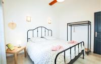 a bedroom with a bed with pink pillows on it at Cozy Home In Merindol With Outdoor Swimming Pool in Mérindol