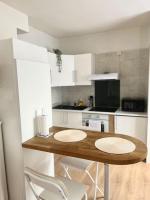 a kitchen with a wooden table and white chairs at F2 Bohémien au centre ville in Corbeil-Essonnes