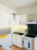a kitchen with white cabinets and a sink at F2 Bohémien au centre ville in Corbeil-Essonnes
