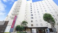 Un edificio blanco con un cartel delante. en Hotel Resol Machida, en Machida