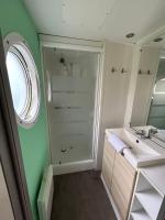 a bathroom with a shower and a sink and a mirror at LE ILÔ - camping la dune blanche in Camiers