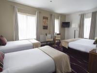 a hotel room with two beds and a table at Arlington Hotel O'Connell Bridge in Dublin