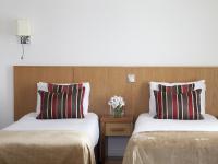 a hotel room with two beds and a vase of flowers at Arlington Hotel O'Connell Bridge in Dublin