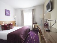 a hotel room with a large bed and a desk at Arlington Hotel O'Connell Bridge in Dublin