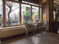 a restaurant with a table and chairs in front of a window at Arlington Hotel O'Connell Bridge in Dublin