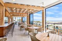a restaurant with tables and chairs and large windows at SpringHill Suites by Marriott Jacksonville Beach Oceanfront in Jacksonville Beach