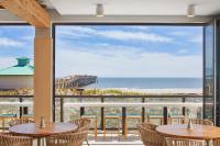 a view of the beach from a restaurant with tables and chairs at SpringHill Suites by Marriott Jacksonville Beach Oceanfront in Jacksonville Beach