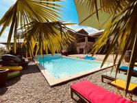 a swimming pool with two chairs and an umbrella at Le Planzollais in Planzolles