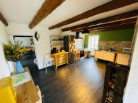 a large kitchen with wooden floors and green walls at Le Planzollais in Planzolles