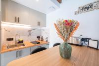 a vase with flowers sitting on a table in a kitchen at Le Petit Rex in Paris