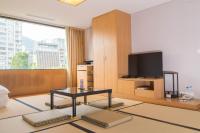 a living room with a table and a tv at Beitou Sweet Me Hot Spring Resort in Taipei