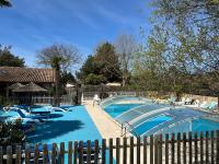 a swimming pool with chairs and a fence at Mobil home PREMIUM 35m2 3 chambres 6 personnes in Arès