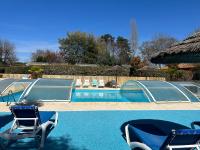 a swimming pool with two lawn chairs and a swimming pool at Mobil home PREMIUM 35m2 3 chambres 6 personnes in Arès