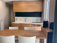 a kitchen with a wooden table and white chairs at Mobil home PREMIUM 35m2 3 chambres 6 personnes in Arès