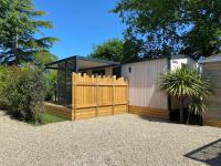a wooden fence in front of a house at Mobil home PREMIUM 35m2 3 chambres 6 personnes in Arès