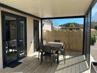 a patio with a table and chairs on a deck at Mobil home PREMIUM 35m2 3 chambres 6 personnes in Arès