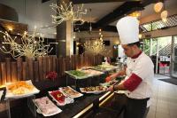 BestView Maisons Private Beach Suites Port Dickson في بورت ديكسون: شيف واقف في مطبخ يحضر طعام