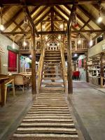 Una habitación grande con suelos de madera y vigas de madera. en The 2 Magpies, Hunza, en Alīābād