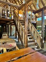 Una escalera de madera en un edificio de madera con una mesa. en The 2 Magpies, Hunza, en Alīābād