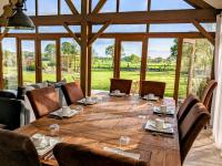 a large wooden table in a room with a large window at Chambres d&#39;hôtes chez l&#39;habitant - Bed&amp; Breakfast homestay in Huisnes-sur-Mer