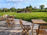 a patio with two tables and chairs and a playground at Chambres d&#39;hôtes chez l&#39;habitant - Bed&amp; Breakfast homestay in Huisnes-sur-Mer