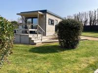 a small house with a porch and a grass yard at Le Theven in Sibiril