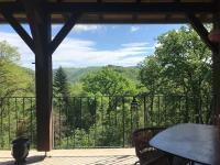 a screened in porch with a table and a view of the mountains at Château de Bataillé in Figeac