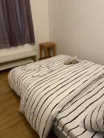 a bed with a black and white striped comforter at Beau F2 Paris face gare de Rosny in Rosny-sous-Bois
