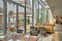 a restaurant with tables and chairs and windows at Augustine, a Luxury Collection Hotel, Prague in Prague