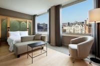 a hotel room with a bed and a chair and a window at Le Méridien Vienna in Vienna
