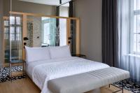 a bedroom with a white bed with a wooden headboard at Le Méridien Vienna in Vienna
