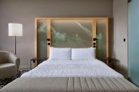 a bedroom with a bed with a headboard and a chair at Le Méridien Vienna in Vienna