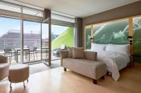 a bedroom with a bed and a chair and a balcony at Le Méridien Vienna in Vienna
