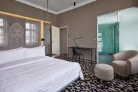 a bedroom with a bed and a desk and a chair at Le Méridien Vienna in Vienna