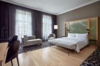 a hotel room with a bed and a chair at Le Méridien Vienna in Vienna