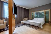 a hotel room with a bed and a flat screen tv at Le Méridien Vienna in Vienna