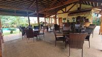 een restaurant met tafels en stoelen en een zwembad bij Alona42 Resort in Panglao